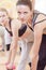 Portrait of Three Nice and Attractive Fitwomen Having a Stretching Workout With Barbelles Indoors Together