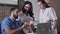 Portrait of three positive multi-ethnic dentists discussing teeth cast. Middle Eastern man and Caucasian women examining