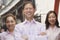 Portrait of three smiling well-dressed people standing in a row, Beijing