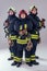 Portrait three strong fireman men in fireproof uniform white background studio