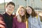 Portrait of three teen friends boy and two girls smiling and taking a selfie outdoors