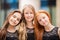 Portrait of three teenage girls with loose hair, blonde, redhead and brunette Summer on street. Vloses develop in wind