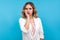 Portrait of tired bored young woman leaning on hand, looking indifferently with gloomy face. blue background