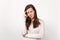 Portrait of tired displeased young woman in light clothes putting hand on head, looking camera isolated on white