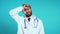 Portrait of tired doc man in professional medical white coat is isolated on blue