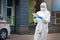 Portrait of tired exhausted female doctor, scientist or nurse wearing face mask and biological hazmat ppe suit reading who