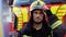 Portrait of tired fireman in protective helmet near fire engine