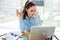 Portrait of tired sick businesswoman holding glass with water taking pills and working with computer