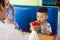 Portrait of todler kid with his parents eating cake