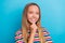 Portrait of toothy beaming schoolgirl with long hairstyle wear colorful t-shirt smiling fingers on chin isolated on blue