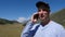 Portrait tourist man calling to mobile phone on mountain landscape