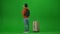 Portrait of traveler isolated on chroma key green screen background. Man with suitcase checking departure board time