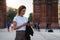 Portrait traveler woman in white t-shirt writes message on smart phone walking arc de Triomphe of Barcelona, tourist girl