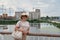 Portrait of travelling woman in hat against the backdrop of the river and city