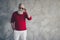 Portrait of trendy stylish gorgeous old man have red modern jumper white pants trousers feel elegant on christmas time
