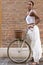 Portrait of turist woman dressed in white on a bicycle, Ferrara. Italy