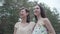 Portrait two adorable smilling young women wear summer dresses standing in the top of rock and looking nature. Pretty