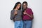 Portrait of a two african girlfriends showing thumbs up sign on gray background