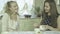 Portrait of two attractive smiling young women having tea at dining table