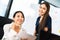 Portrait of two beautiful Asian office coworkers smiling together at work. Business colleagues, teamwork partner, job consultant