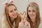 portrait of two beautiful young girls doing sweet heart with Christmas candys