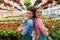 Portrait of two beautiful young women entrepreneurs in flower greenhouse