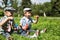 Portrait of two boys children sitting on the grass blowing soap