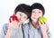 Portrait of two boys, twins holding red and green apples