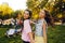 Portrait of a two brunette in a park at a festival. A two sister friends in pink dance.  Girls posing, dancing, smiling on a