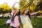 Portrait of a two brunette in a park at a festival. A two sister friends in pink dance.  Girls posing, dancing, smiling on a