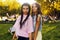 Portrait of a two brunette in a park at a festival. A two sister friends in pink dance.  Girls posing, dancing, smiling on a