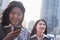 Portrait of two businesswomen, one looking at phone, outdoors Beijing