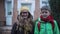 Portrait of two Caucasian children waving back their parent, looking at camera and laughing. Schoolmates with backpacks