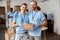 Portrait of two caucasian guys, male volunteers in blue uniform, protective gloves smiling at camera and holding