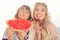 Portrait of two charming lovely cheerful woman hold watermelon slice strawberry kiss lips toothy smile free time outside