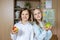 Portrait of two cute caucasian young blond little classmate friend kids eating apple in classroom at lunch time pause