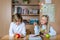 Portrait of two cute caucasian young blond little classmate friend kids studying in classroom at daycare time