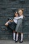 Portrait of two cute little schoolgirl friends. Posing in front of the wall