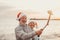 Portrait of two cute old persons having fun and enjoying together at the beach on christmas days at the beach wearing Christmas