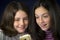 Portrait of two cute sisters looking at cell phone