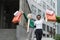 Portrait of two diverse young women, African and Muslim, holding colorful shopping bags