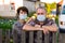 Portrait of two farmers wearing protective masks at fence of their country house