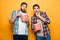 Portrait of a two frightened young men eating popcorn