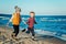 Portrait of two funny white Caucasian children kids friends playing running on ocean sea beach on sunset