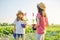 Portrait of two girls children with flowers in pots, gloves, with garden shovels