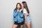 Portrait of a two girls gossip on gray background