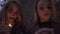 Portrait of two girls with halloween makeup on faces holding small candles in hands looking in camera. Horror night of