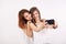 Portrait of two gorgeous young woman, a redhair and a brown-haired, taking a selfie