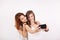 Portrait of two gorgeous young woman, a redhair and a brown-haired, taking a selfie