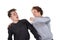 Portrait of two handsome and young furious men fighting with each other on white background